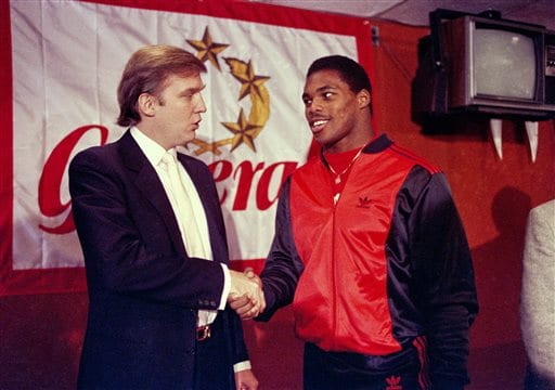 FILE - In this March 8, 1984, file photo, Donald Trump shakes hands with Herschel Walker in New York after agreement on a 4-year contract with the New Jersey Generals USFL football team. The New Jersey Generals have been largely forgotten, but Trumps ownership of the team was formative in his evolution as a public figure and peerless self-publicist. With money and swagger, he led a shaky and relatively low-budget spring football league, the USFL, into a showdown with the NFL. (AP Photo/Dave Pickoff, File)
